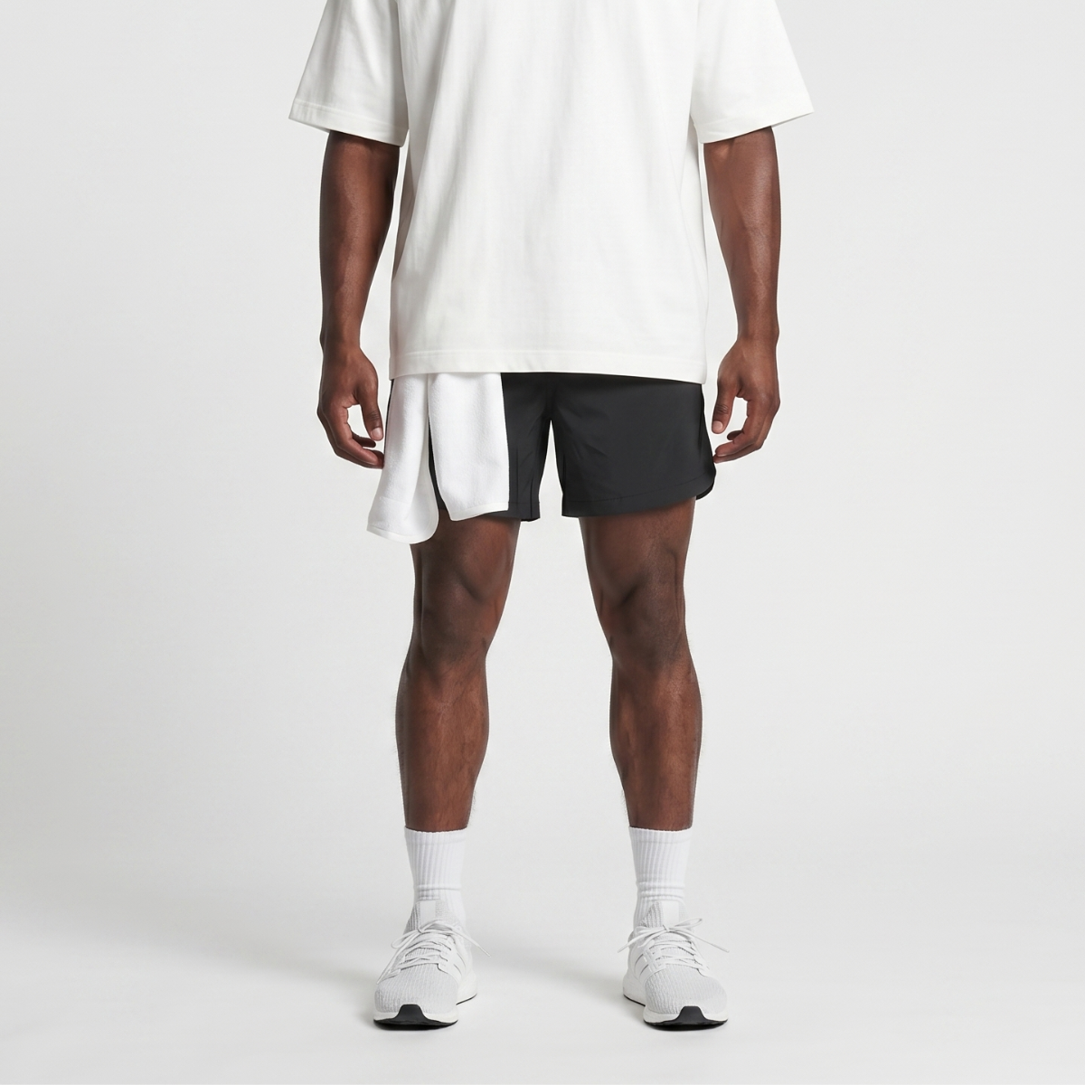 Black running shorts worn with a white oversized tee, white crew socks and white trainers